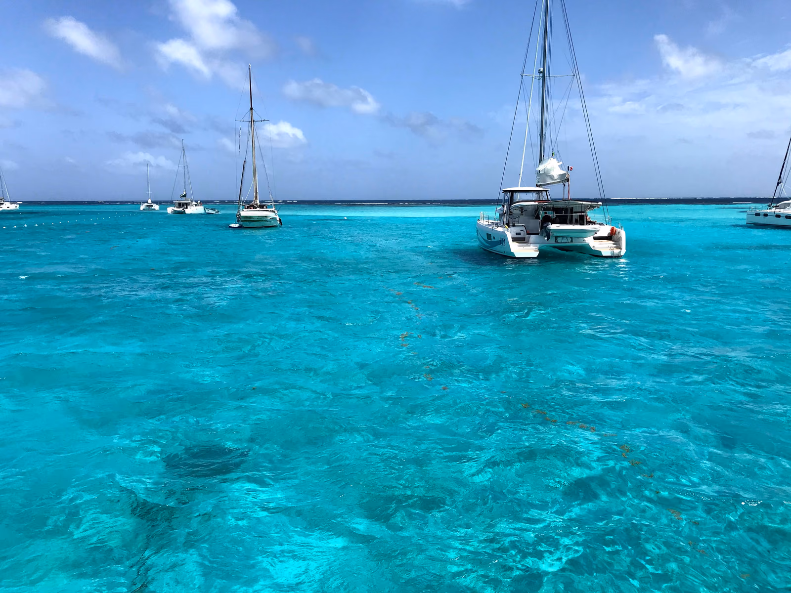 Catamaran anchored in a shallow turquoise Caribbean lagoon